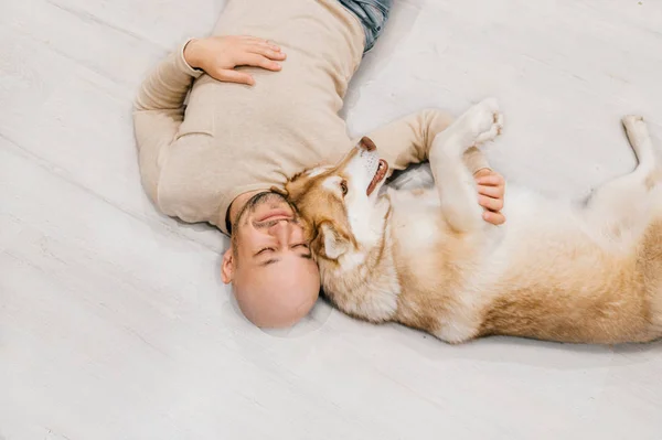 Mann Liegt Mit Husky Hund Auf Dem Boden — Stockfoto