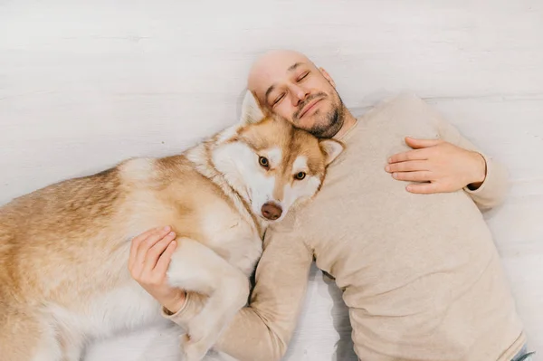 Mann Liegt Mit Husky Hund Auf Dem Boden — Stockfoto