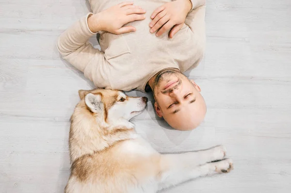 Mann Liegt Mit Husky Hund Auf Dem Boden — Stockfoto