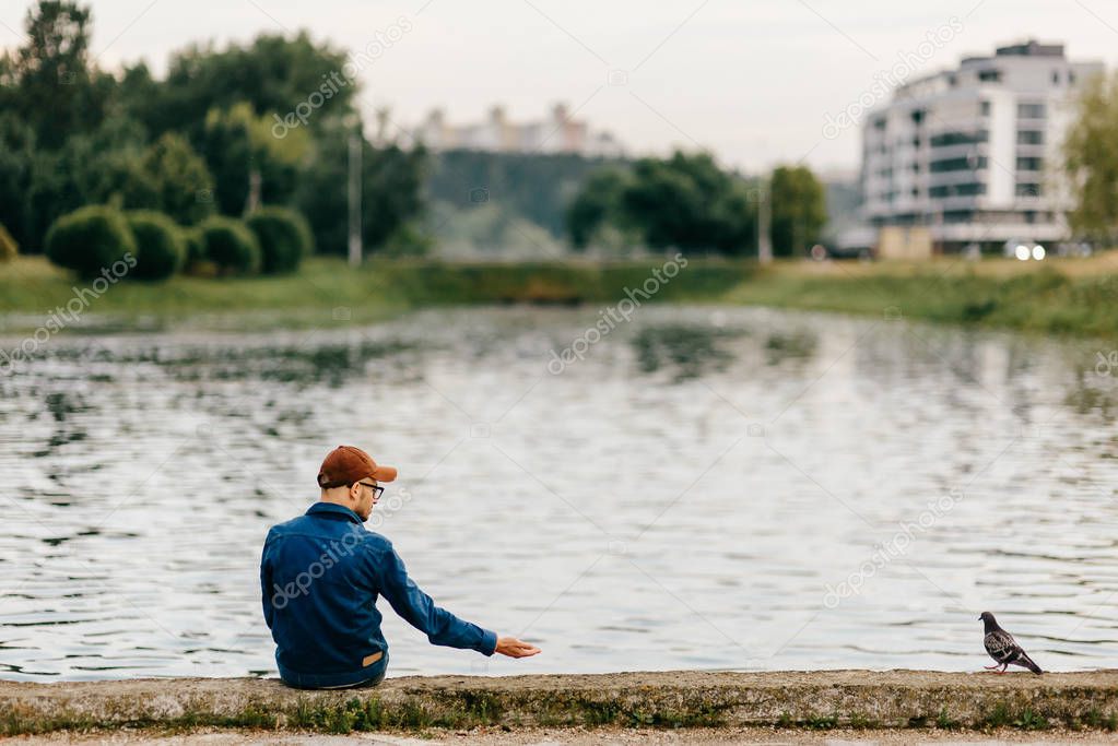 lonely man sitting on edge of embankment outdoor