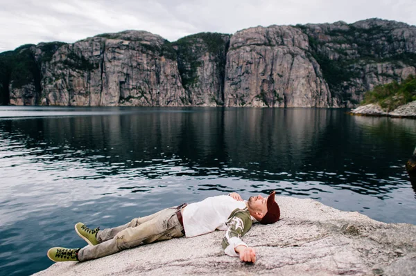 Homem Viajante Jeans Boné Sapatos Deitado Pedra Além Fiorde Noruega — Fotografia de Stock
