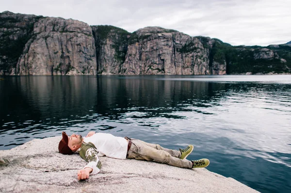 Cestovatelů Muž Džínách Čepici Boty Leží Kameni Nad Fjordu Norsku — Stock fotografie