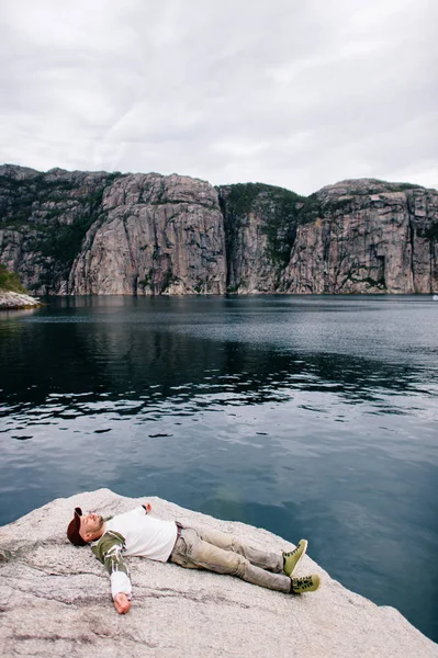 Cestovatelů Muž Džínách Čepici Boty Leží Kameni Nad Fjordu Norsku — Stock fotografie