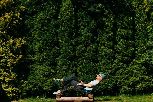Мужчина Расслабляется Шезлонге Бассейном Вилле Сицилии Стеной Зеленых Южных Деревьев — стоковое фото