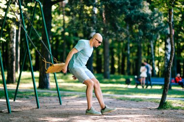 yetişkin adam tarih bahçesi yaz parkta salıncakta sallanan atlama