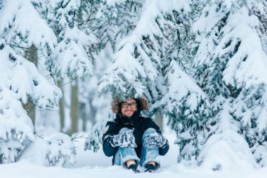karlı kış ormanda zemin üzerinde oturan adam