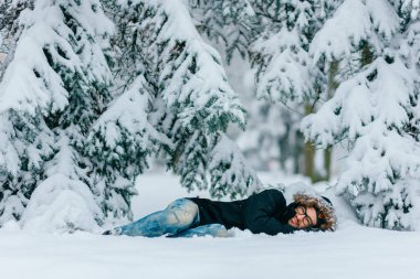 karlı kış ormanda zemin üzerinde yatan adam