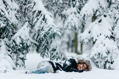 karlı kış ormanda zemin üzerinde yatan adam