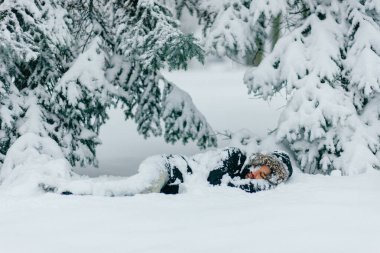karlı kış ormanda zemin üzerinde yatan adam