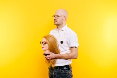 kel adam Sarı zemin üzerinde plastik manken kafa tutan