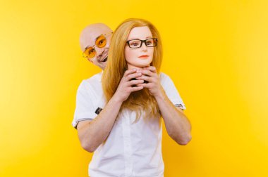 kel adam Sarı zemin üzerinde plastik manken kafa tutan