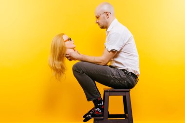 kel adam Sarı zemin tahta sandalyede otururken plastik manken kafa tutan