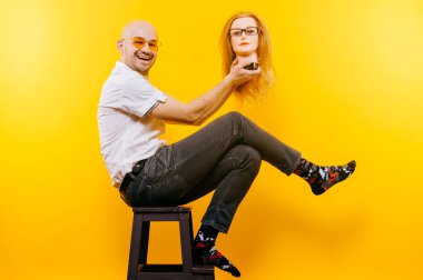 kel adam Sarı zemin tahta sandalyede otururken plastik manken kafa tutan