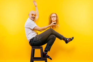 kel adam Sarı zemin tahta sandalyede otururken plastik manken kafa tutan