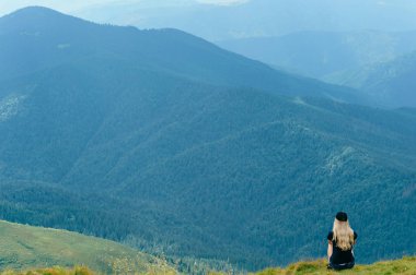 arkadan görünüşü güzel Karpat Dağları'nda sarışın kadın yaz gününde