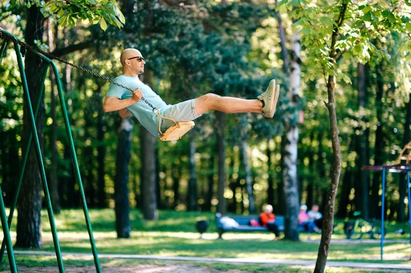 Erwachsener Mann Schwingt Auf Schaukel Auf Spielplatz Sommerpark — Stockfoto