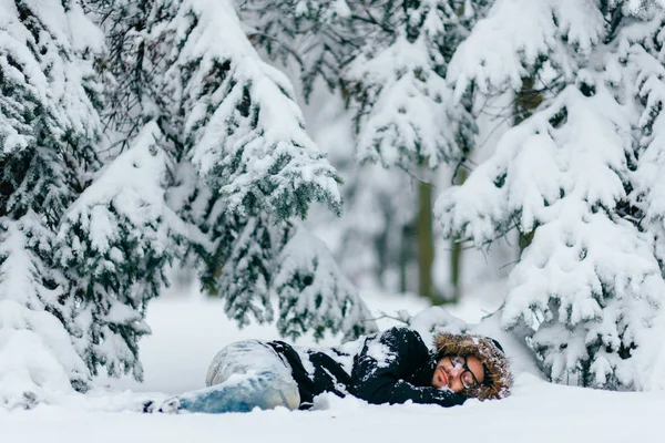 karlı kış ormanda zemin üzerinde yatan adam