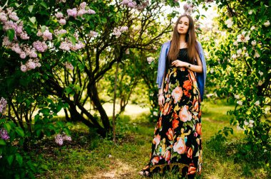 Genç güzel kadın yaz çiçek açan bahçesinde