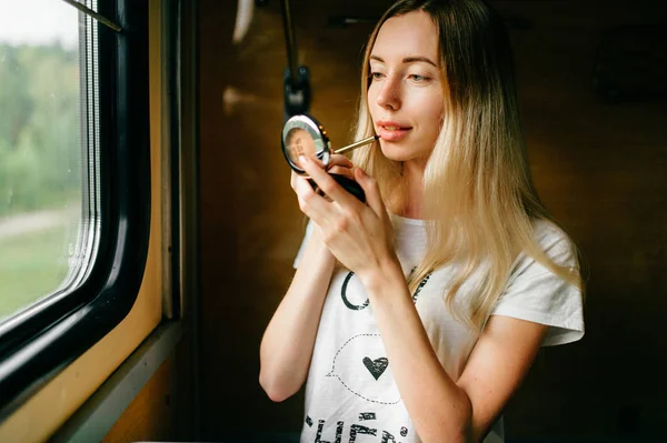 Junge Frau Mit Langen Haaren Trägt Lippenstift Auf Während Sie — Stockfoto