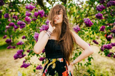 Genç güzel kadın yaz çiçek açan bahçesinde