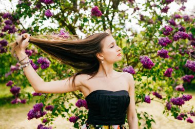 Genç güzel kadın yaz çiçek açan bahçesinde