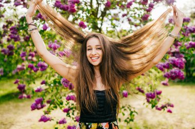 Genç güzel kadın yaz çiçek açan bahçesinde