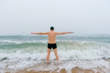 adam soğuk fırtınalı denizde ayakta