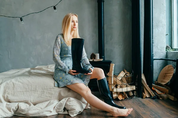 Beautiful Young Blonde Woman Sitting Sofa While Holding Black Boot — Stock Photo, Image