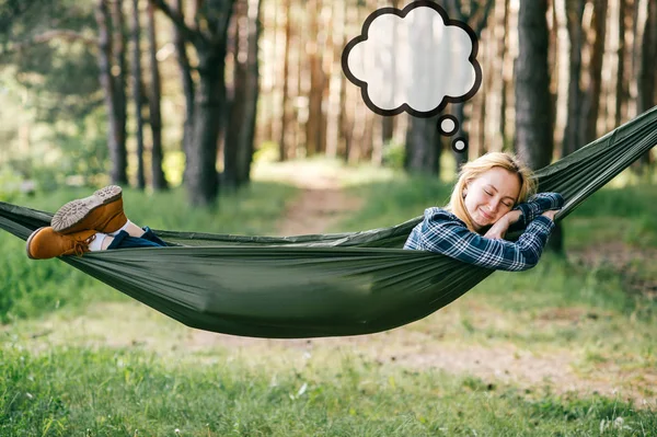 young woman sleeping in hammock in forest