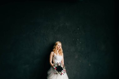 karanlık duvar arka plan üzerinde poz beyaz şık gelinlik güzel zarif gelin