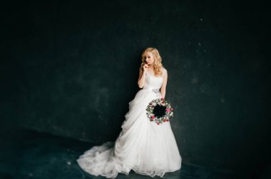 karanlık duvar arka plan üzerinde poz beyaz şık gelinlik güzel zarif gelin