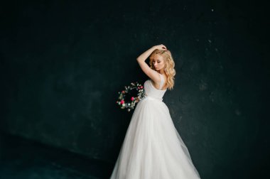 karanlık duvar arka plan üzerinde poz beyaz şık gelinlik güzel zarif gelin