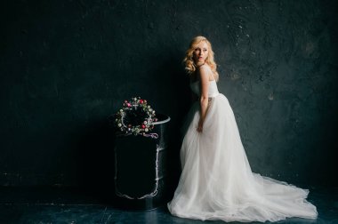 karanlık duvar arka plan üzerinde poz beyaz şık gelinlik güzel zarif gelin