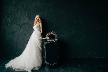 karanlık duvar arka plan üzerinde poz beyaz şık gelinlik güzel zarif gelin