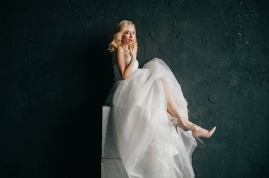karanlık duvar arka plan üzerinde poz beyaz şık gelinlik güzel zarif gelin