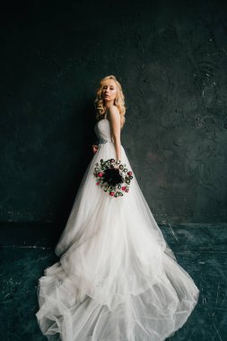 karanlık duvar arka plan üzerinde poz beyaz şık gelinlik güzel zarif gelin