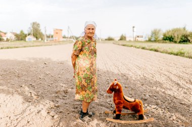 yaşlı kadın ve oyuncak at yaz alanında