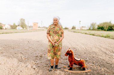 yaşlı kadın ve oyuncak at yaz alanında