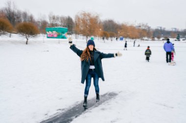 Eğleniyor donmuş gölde kış gününde genç güzel kadın