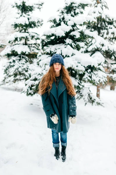 若い美しい女性が冬の日の雪に覆われた森林のポーズ — ストック写真