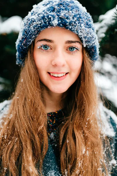 若い美しい女性が冬の日の雪に覆われた森林のポーズ — ストック写真
