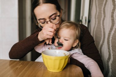 küçük kızının evde lezzetli çorba ile beslenme anne