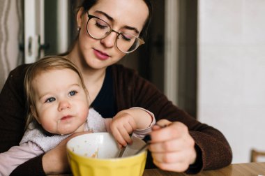 küçük kızının evde lezzetli çorba ile beslenme anne