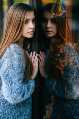 ayna yansıması ile vitrin önünde poz genç güzel kadın