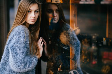 ayna yansıması ile vitrin önünde poz genç güzel kadın