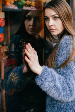 ayna yansıması ile vitrin önünde poz genç güzel kadın