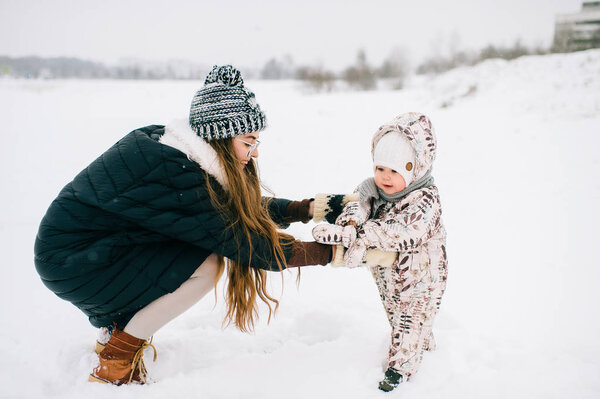 young mother with little daughter on winter day