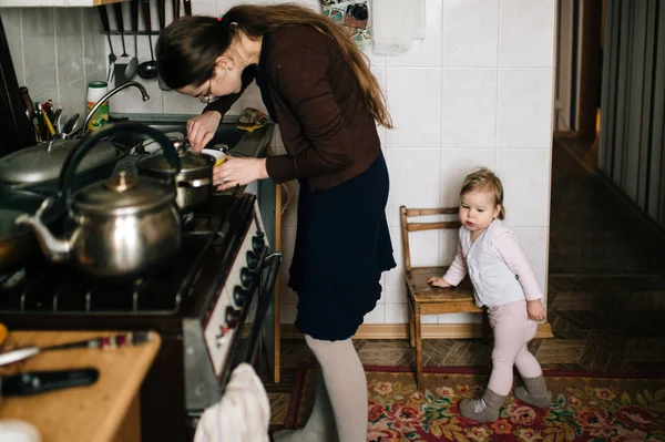 Young Caucasian Housewife Cooking Food Daughter Home — Stock Photo, Image