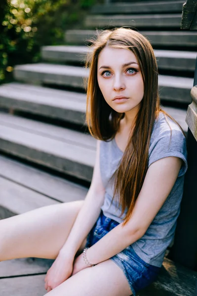 穿着休闲服装的年轻女孩坐在街上的台阶上 — 图库照片