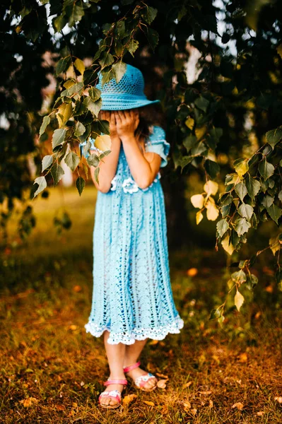 little girl in blue knitted dress and hat